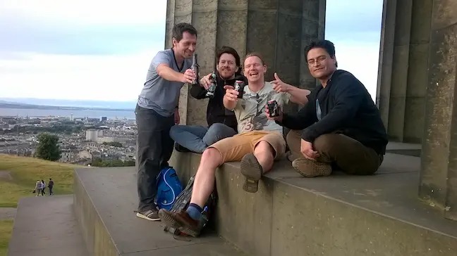 three male persons sitting in a pavillon
